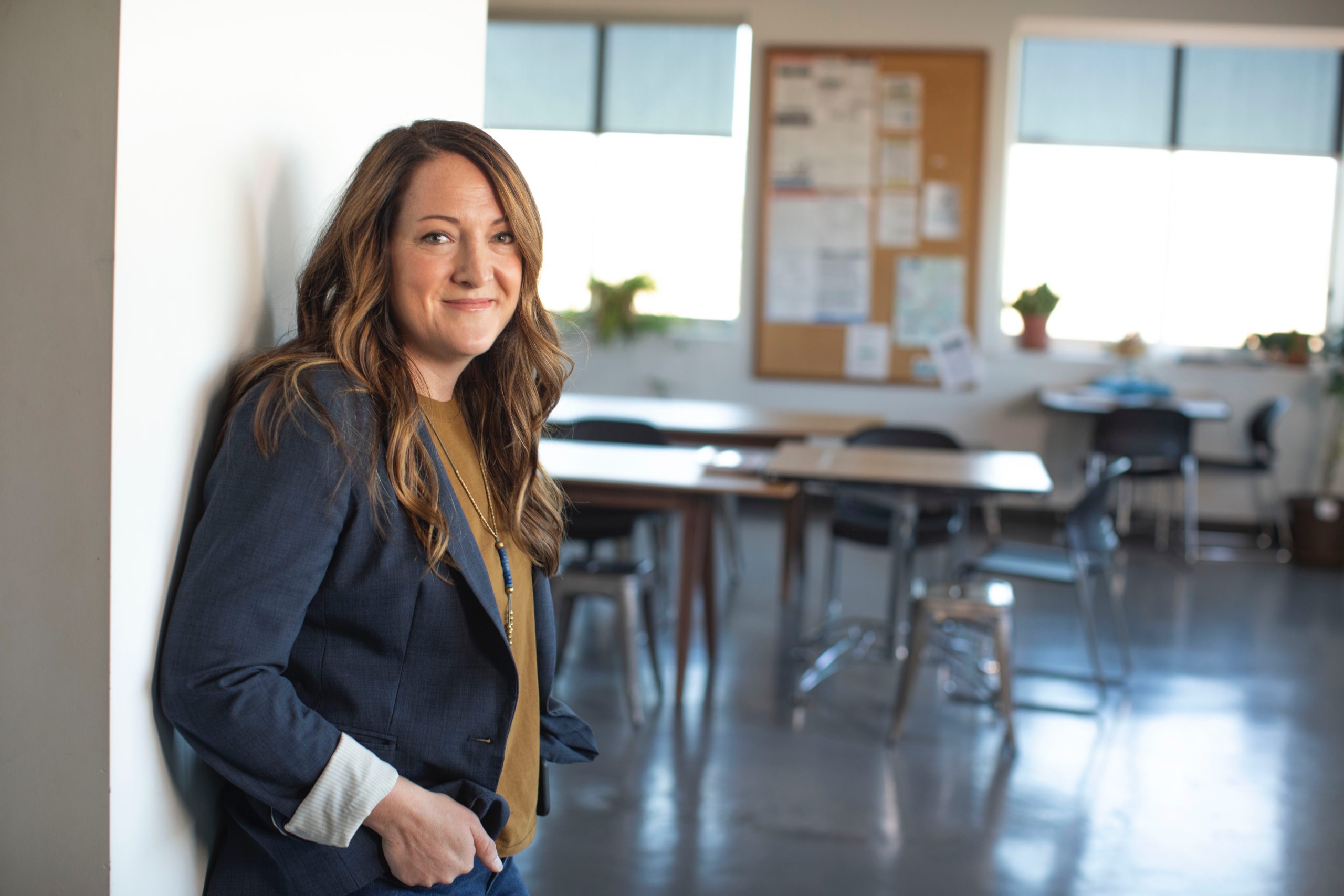 Woman smiling in a classroom setting.