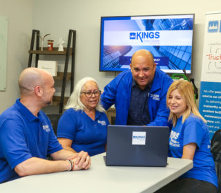 Four employees in front of a computer