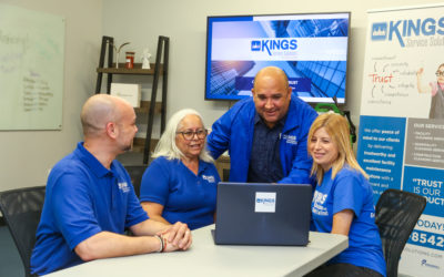 Four employees in front of a computer