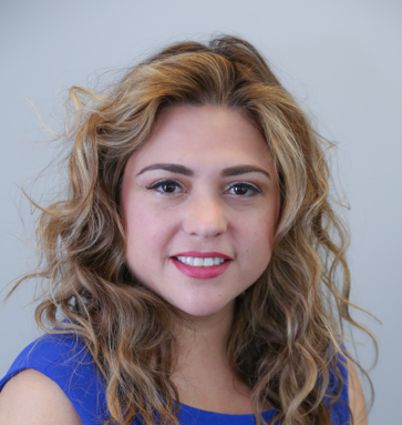 Smiling woman with curly hair, blue top.