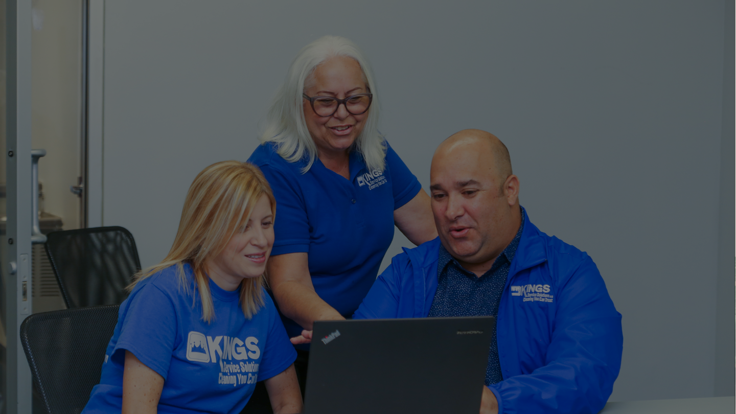 Three people collaborating on a laptop.